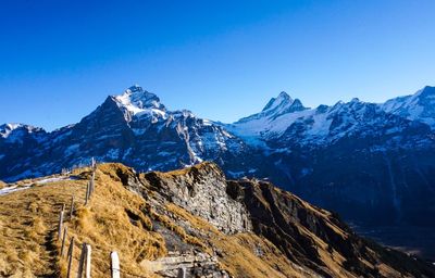 Scenic view of snowcapped mountains against clear blue sky