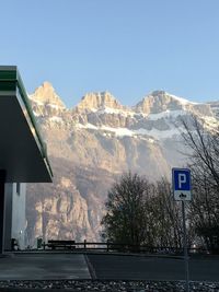 Road sign on mountain against clear sky