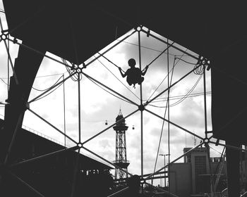 Low angle view of silhouette man on building against sky