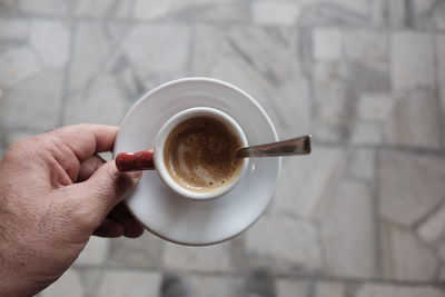 Cropped hand holding coffee cup