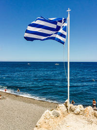 Deck chairs on beach against clear blue sky