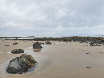 Rocks on beach against sky