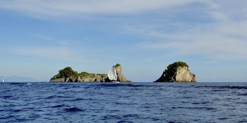 Rock formation in sea against sky
