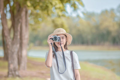 Portrait of woman photographing in park