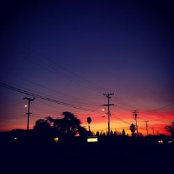 Silhouette of electricity pylon at sunset