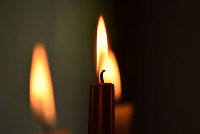 Close-up of burning candle in darkroom