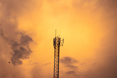 Low angle view of communications tower against sky during sunset