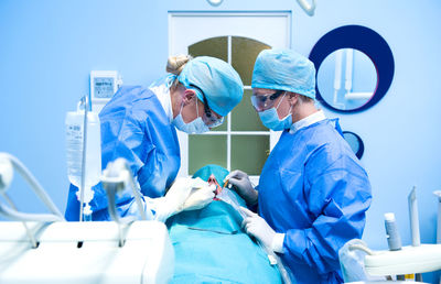 Doctors performing dental implantation in operating room