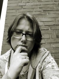 Portrait of beautiful young woman looking away against wall