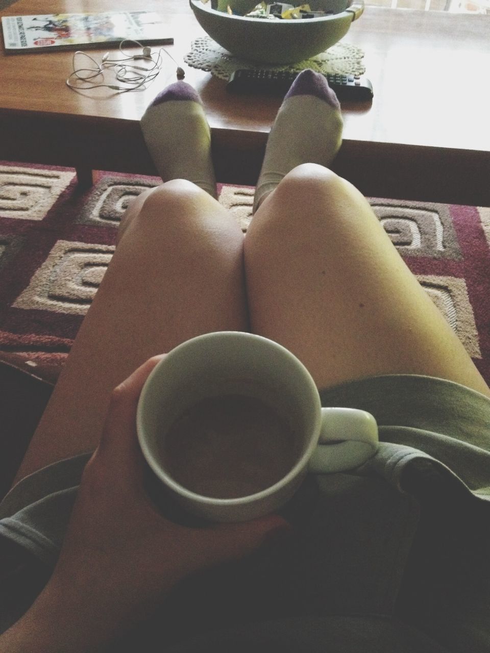 lifestyles, sitting, leisure activity, relaxation, low section, person, high angle view, indoors, part of, personal perspective, men, chair, day, close-up, coffee cup, unrecognizable person