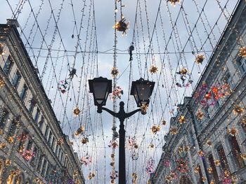 Low angle view of decorations at street hanging against sky