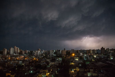 Illuminated city against sky at night