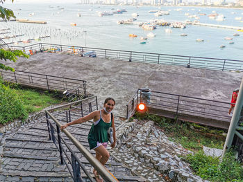 High angle view of woman on railing by sea