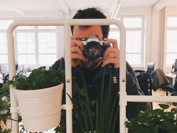 Midsection of man photographing through camera