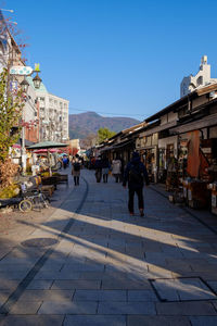 People walking on street against buildings in city