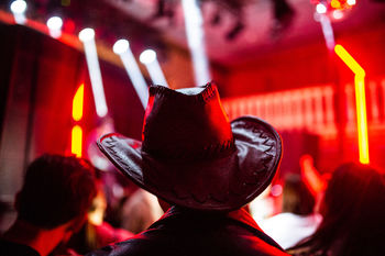 Rear view of man wearing cowboy hat at nightclub