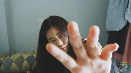 High angle portrait of young woman gesturing while sitting at home