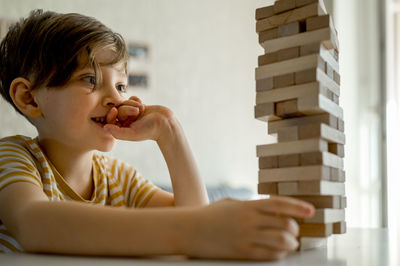 Focused boy playing block removal game at home