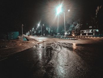Illuminated city street at night during rainy season