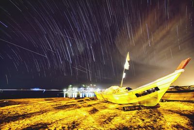 Panoramic view of boats moored in sea at night