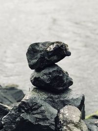 Close-up of stone stack on rock at beach