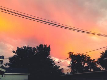 Low angle view of power lines against cloudy sky