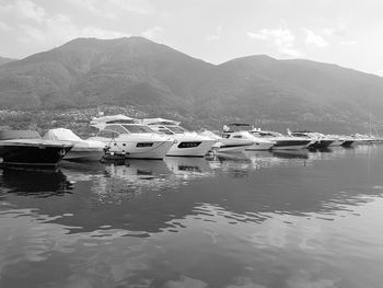 Boats moored on lake against mountains