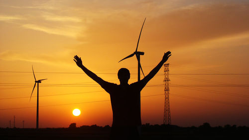 Silhouette of man standing against sunset sky