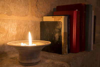 Close-up of illuminated tea light candles on wall