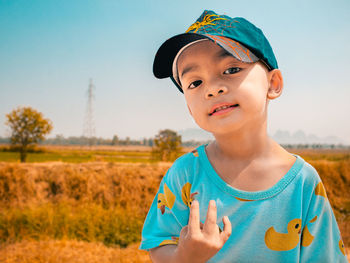 Portrait of boy standing against sky