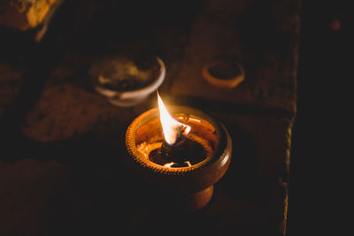 Close-up of lit candle in the dark