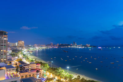 High angle view of illuminated city by buildings against sky