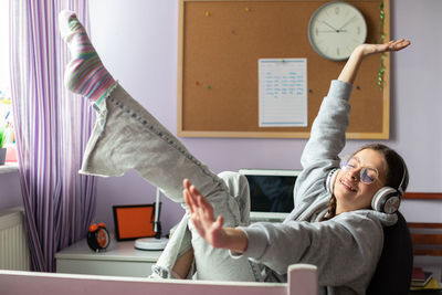 A happy teenager listens to music with wireless headphones.