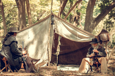 Panoramic view of tent on field against trees in forest