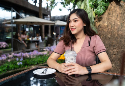 Portrait of a smiling young woman holding drink