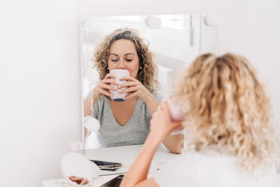 Full length portrait of woman holding coffee cup