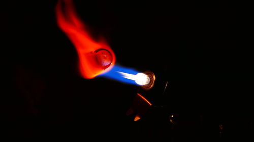 Close-up of illuminated candle against black background