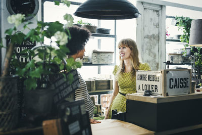 Mid adult female workers communicating in store