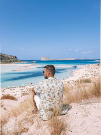 Men on the beach in crete greece during vacation at balos beach