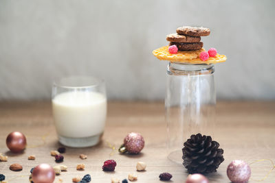 Close-up of milk and cookies with christmas decorations on table