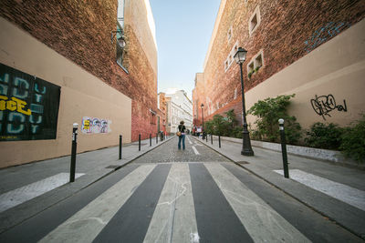 Man walking in city against clear sky