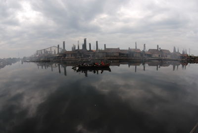 Cranes in city against sky