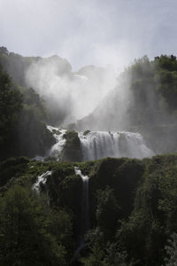 Scenic view of waterfall against sky