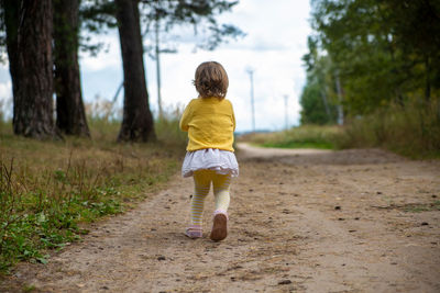 Adorable child run away country road in forest