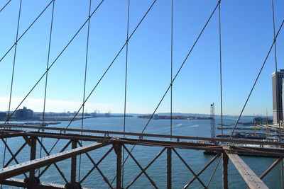 Bridge over sea against clear blue sky