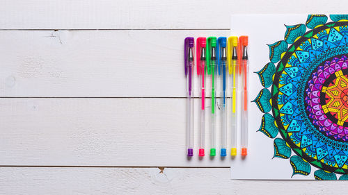 Close-up of pen with colorful paper on table