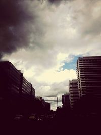 Low angle view of buildings against cloudy sky