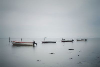 Boats moored on sea against sky