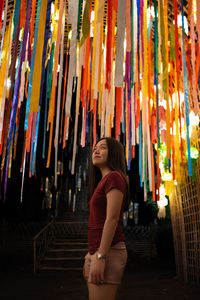 Full length of woman standing against multi colored wall