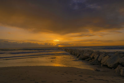 Scenic view of beach against sky during sunset